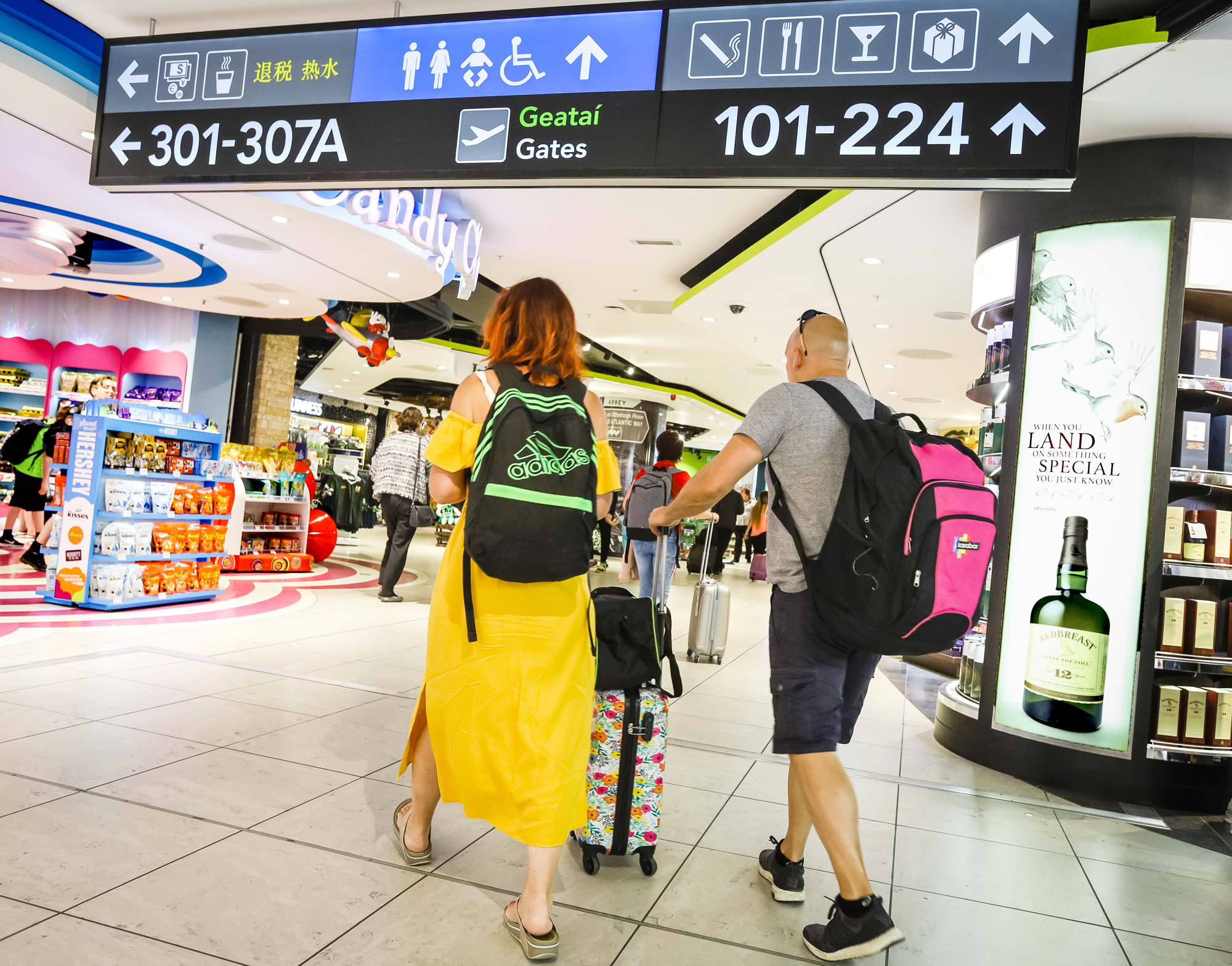 Departing Pax T1 - 6 Passengers walk through The Loop in Terminal 1 Departures
