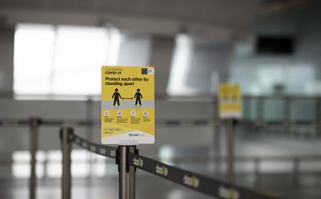 Social distancing signage in Q lane at Dublin Airport.